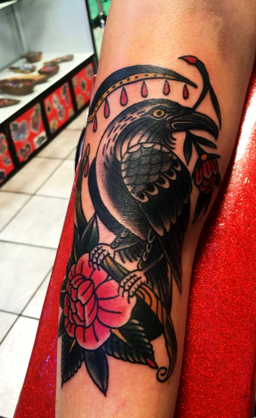 American Traditional crow on rose branch elbow tattoo by Tim Goodrich, Waikiki, Hawaii