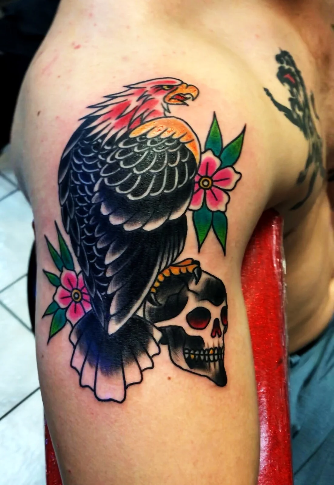 American Traditional eagle perched on skull with cherry blossoms shoulder tattoo by Tim Goodrich, Waikiki, Hawaii