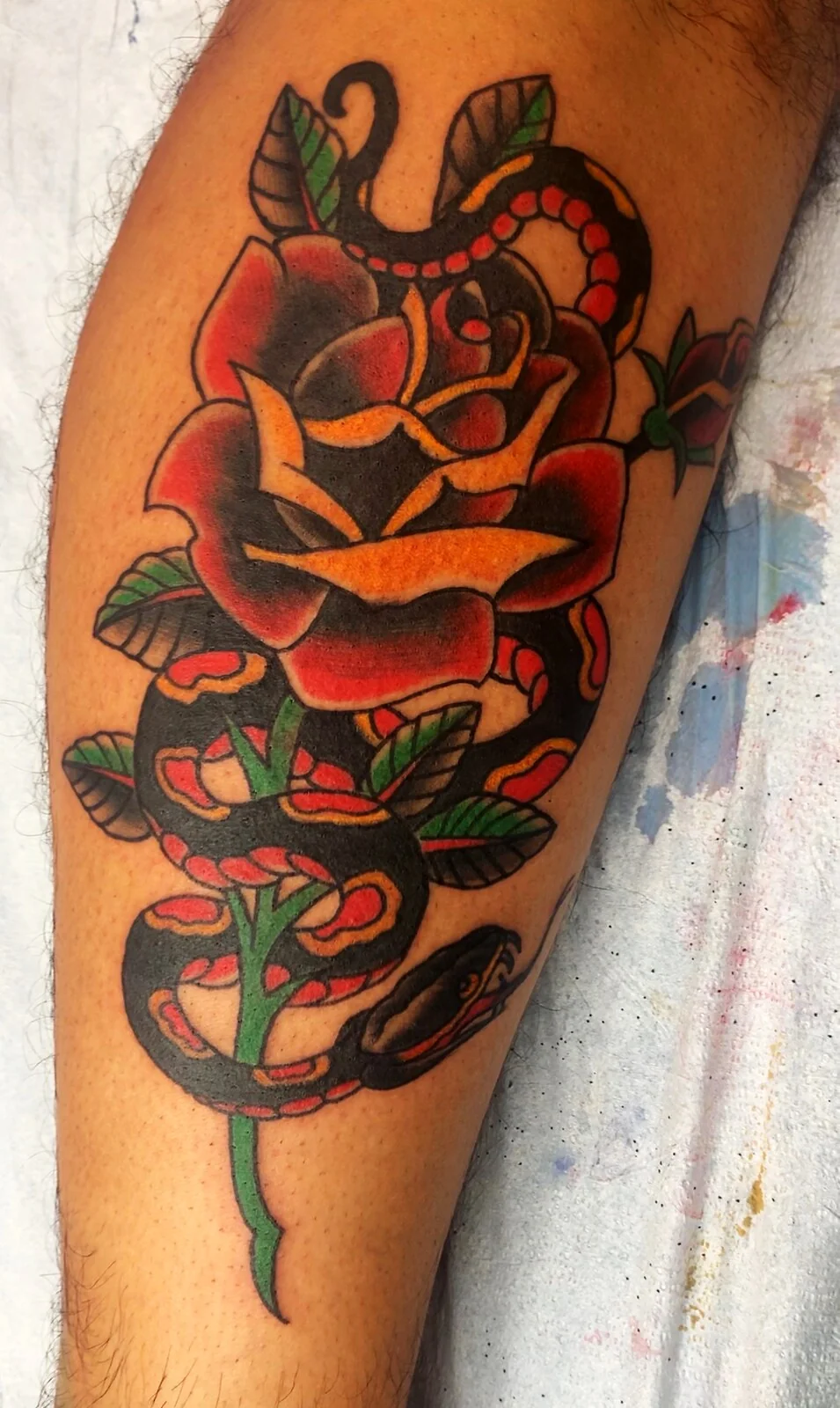 American Traditional red snake coiled around rose calf tattoo by Tim Goodrich, Waikiki, Hawaii